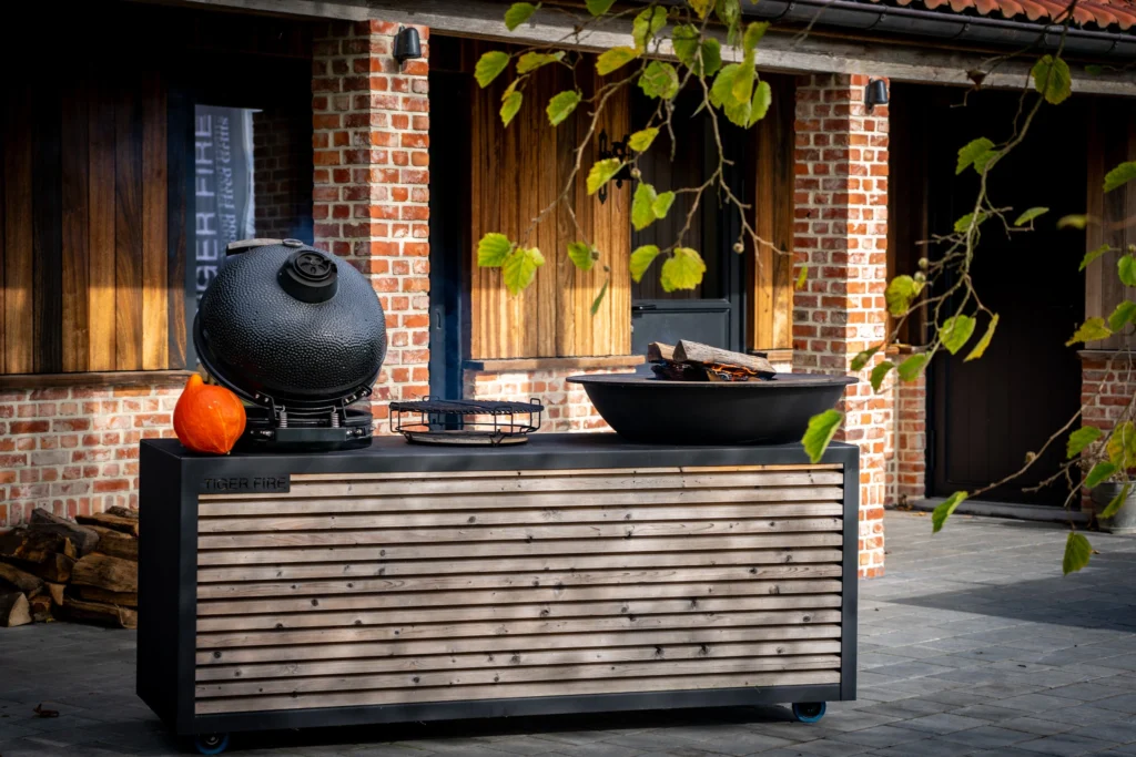 Deze zwart gepoederlakte Black Kitchen met plancha BBQ en Kamado BBQ van TIGER FIRE is ontworpen voor ultieme duurzaamheid en stijl. Perfect voor elke buitenkeuken. Gemaakt van hoogwaardig staal. Ideaal voor het bereiden van heerlijke maaltijden in de buitenlucht, van sappige steaks tot gegrilde groenten. Bekijk meer details en bestel vandaag nog je eigen TIGER FIRE plancha BBQ.